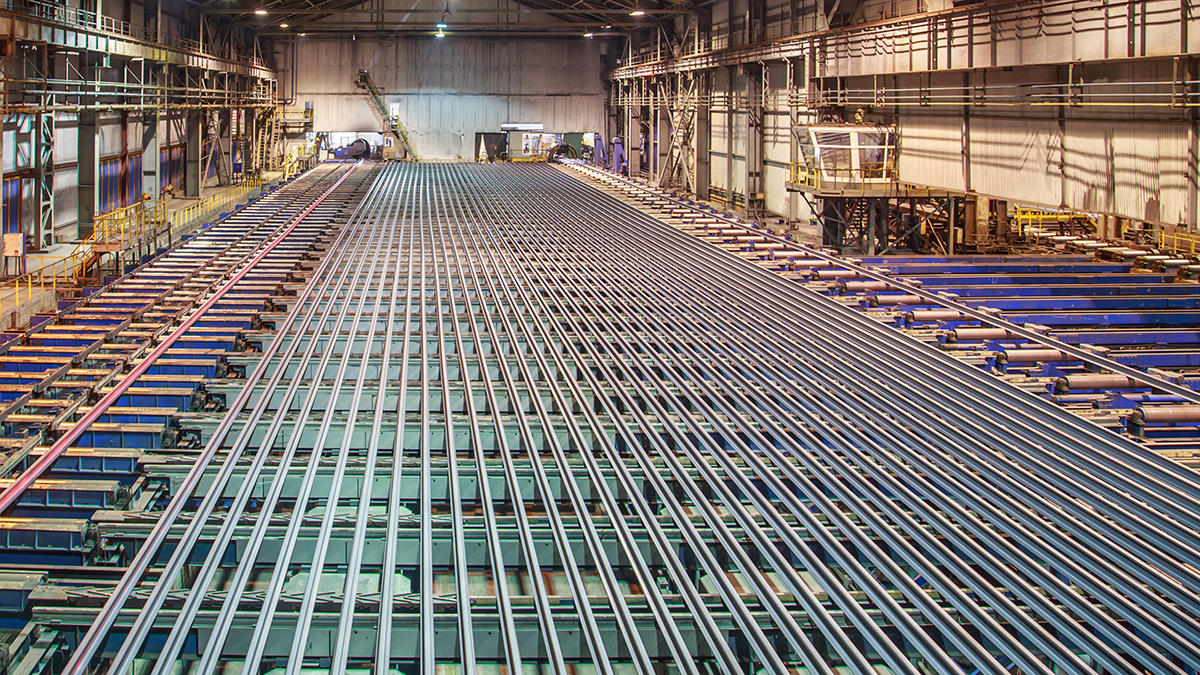 Rolling mill workshop at iron foundry. Stack of steel ingots for railway track.