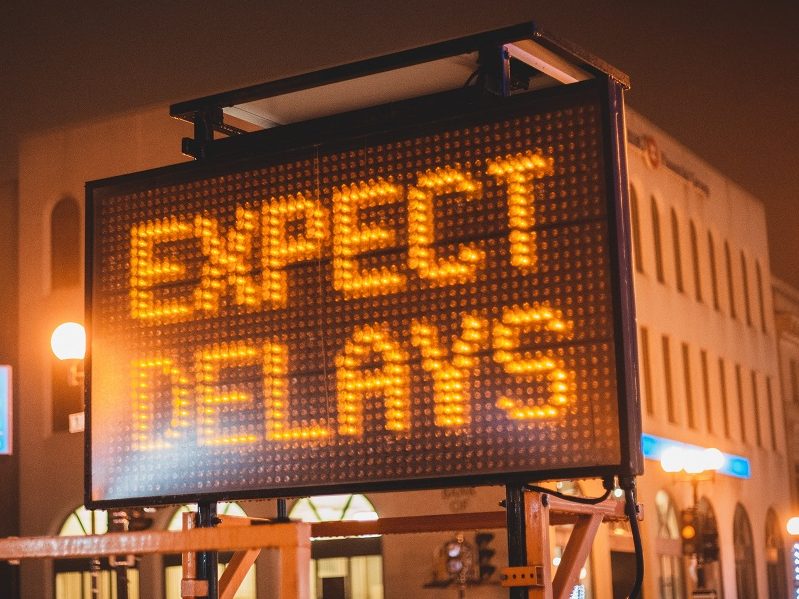 Electronic road sign with the message "EXPECT DELAYS" with Newfoundland and Labrador bank to the left. (in original)