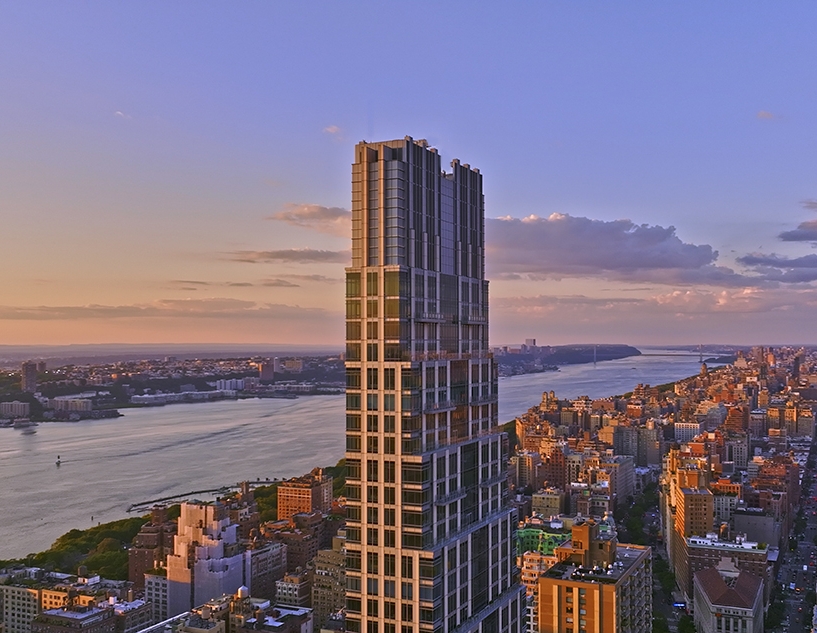 A towering view of 200 Amsterdam, the sleek 52-story condominium on Manhattan’s Upper West Side, with an art‑deco inspired façade combining glass, granite, and limestone.