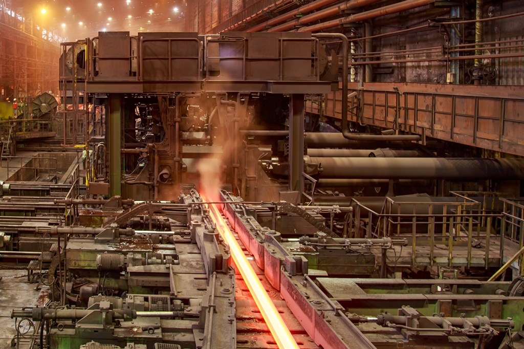 Hot steel billet on rolling mill. Railroad track production at steel mill