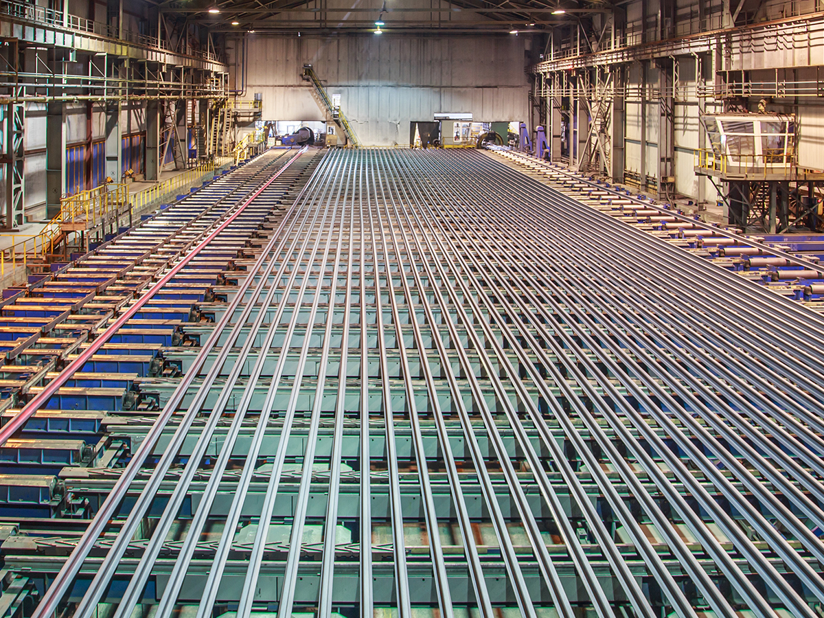 Rolling mill workshop at iron foundry. Stack of steel ingots for railway track.