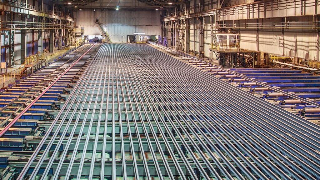Rolling mill workshop at iron foundry. Stack of steel ingots for railway track.