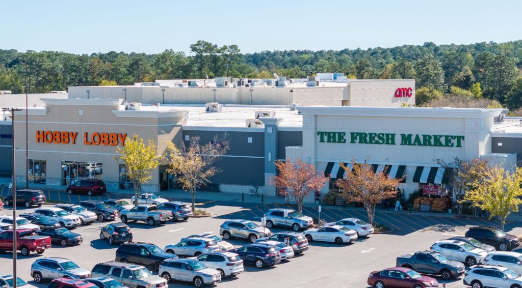 An overhead photo of Jubilee Square, with Hobby Lobby and The Fresh Market visible in the foreground and AMC Theatres behind.