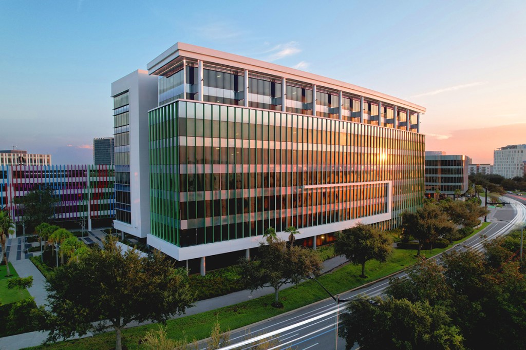 Twilight view of modern, multistory office building with brown and gray highlights