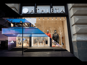 Exterior shot depicting the store front of an Adidas and an Athleta store.