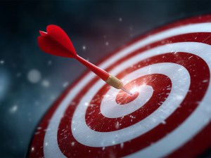 Close-up of dartboard with a single red dart hitting the bullsey