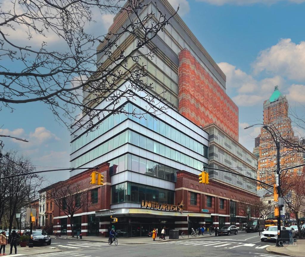 A corner retail building featuring many windows, showcasing a modern architectural design.