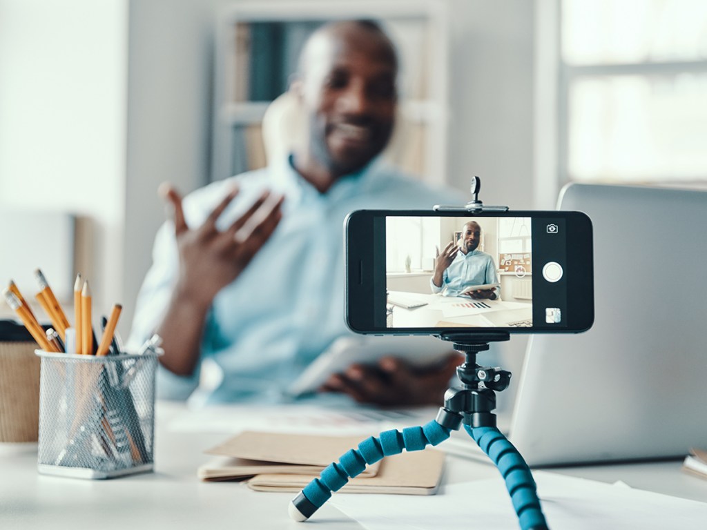 Young man in shirt recording video for social media use