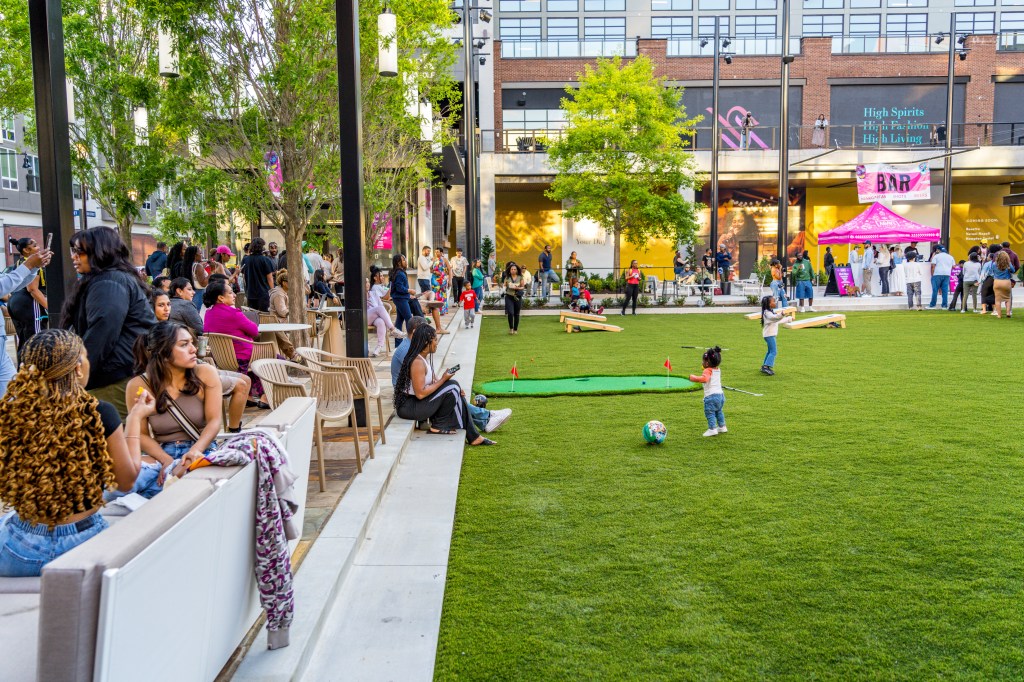 Outdoor activities that include adults and children, taking place in a dedicated green space at High Street in Atlanta