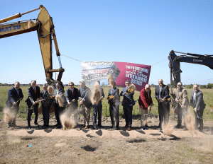 Officials shoveling dirt at the ground breaking of a new mixed-use district in Oklahoma.
