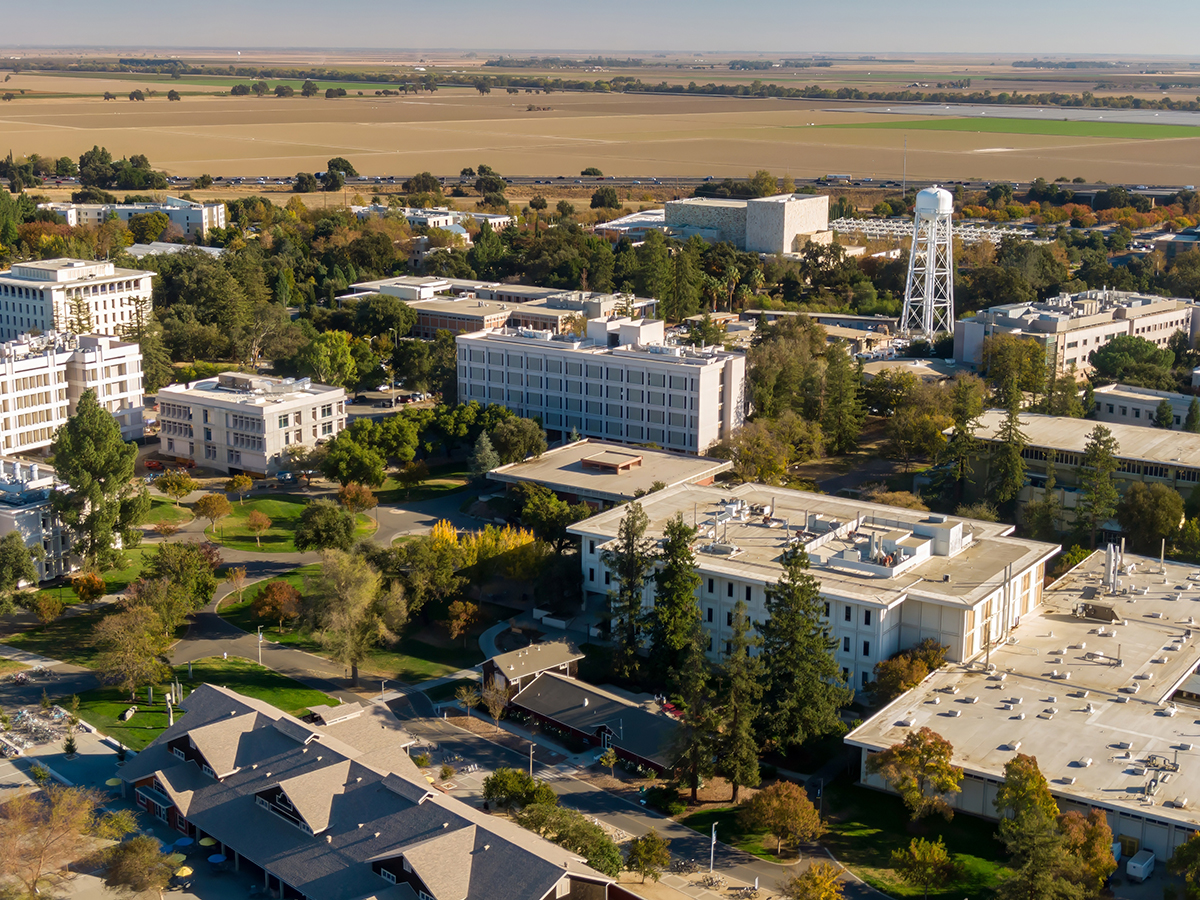 Outside shot of UC Davis campus, showcasing various buildings, trees, and open spaces.