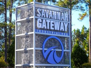 Tall sign reading "Savannah Gateway Industrial Park" with tall trees in background