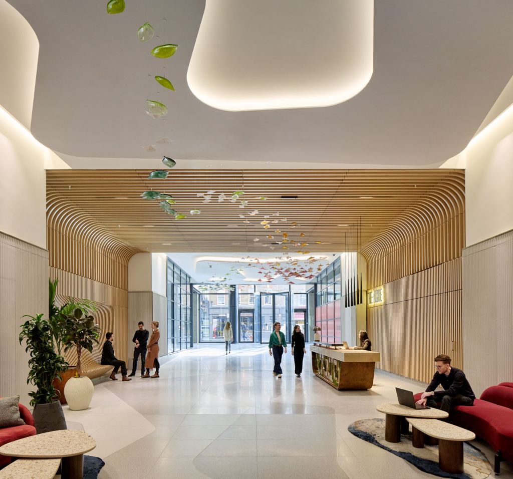 Interior entrance area at The Acre, showing wood finishes, lounge seating and reception space.
