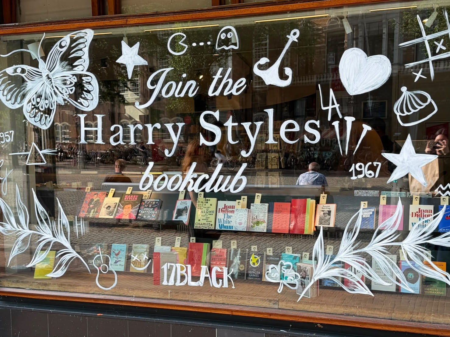 A Styles-themed bookstore window in Amsterdam shows how independent retailers can participate in the fan economy through low-cost, locally tailored activations.
