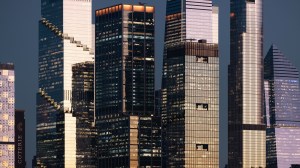 A dense cluster of Manhattan office towers fills the frame, showcasing the reflective interplay of glass, steel, and fading daylight. This detailed look at NYC architecture highlights texture, repetition, and scale.