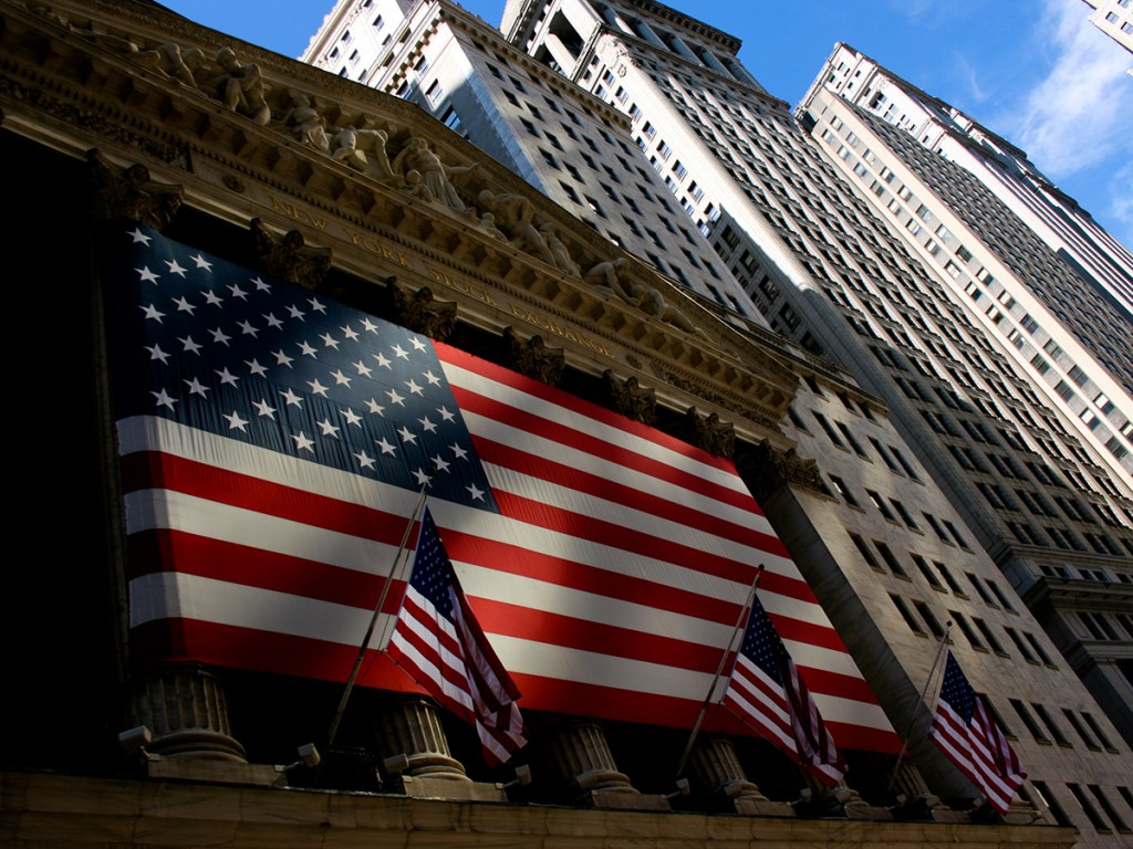 NYSE stock exchange with Wall street architecture and US flagNYSE stock exchange with Wall street architecture and US flag